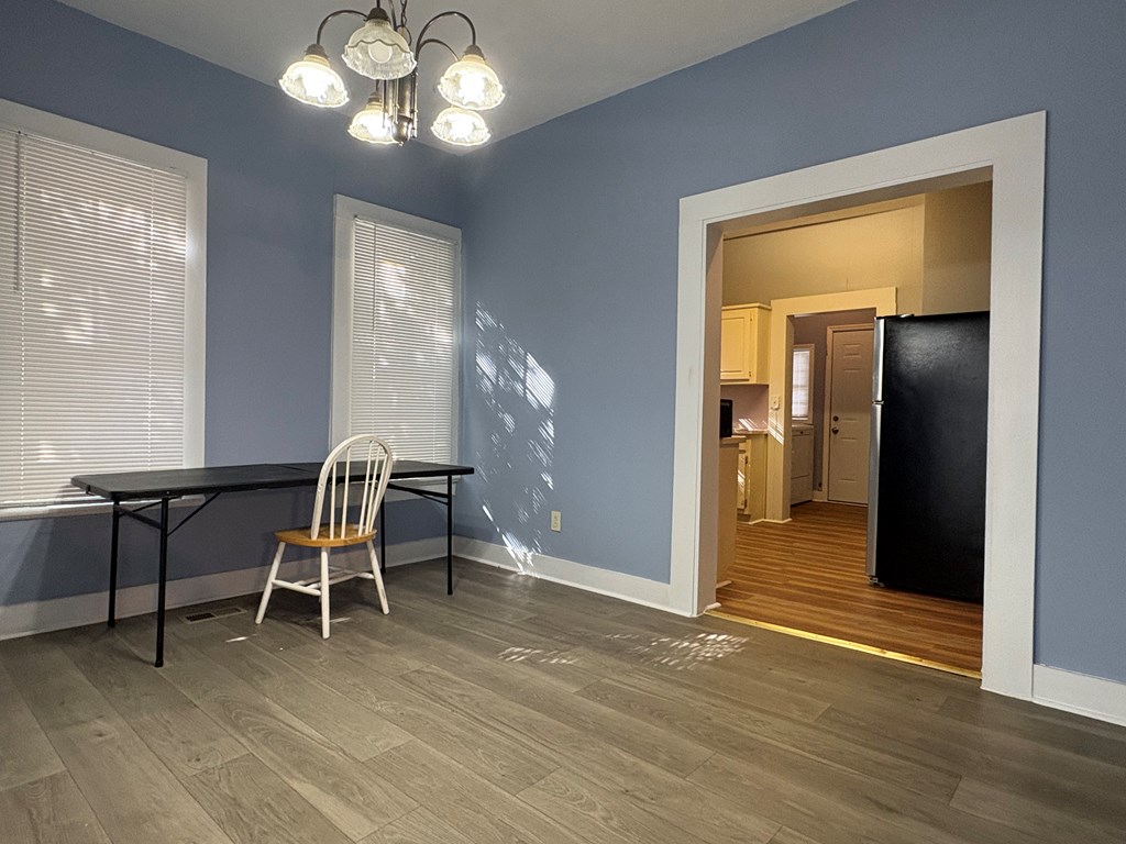 2427 Marion Street Columbus, GA 31906 - Photo 8 of 23 a dining room with wooden floor a potted plant and a chandelier