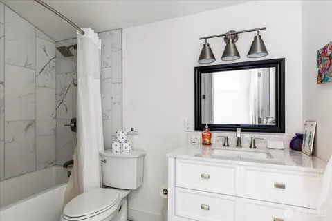 a bathroom with a sink vanity mirror and toilet