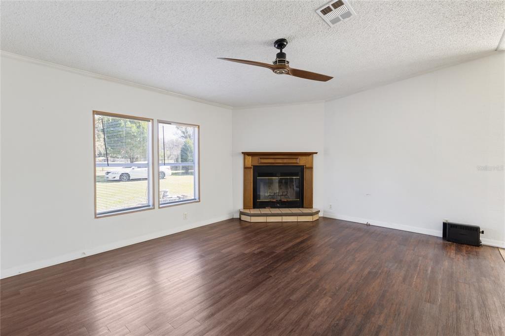 4912 Miley Road Plant City, FL 33565 - Photo 25 of 48 a view of an empty room with wooden floor fireplace and a window