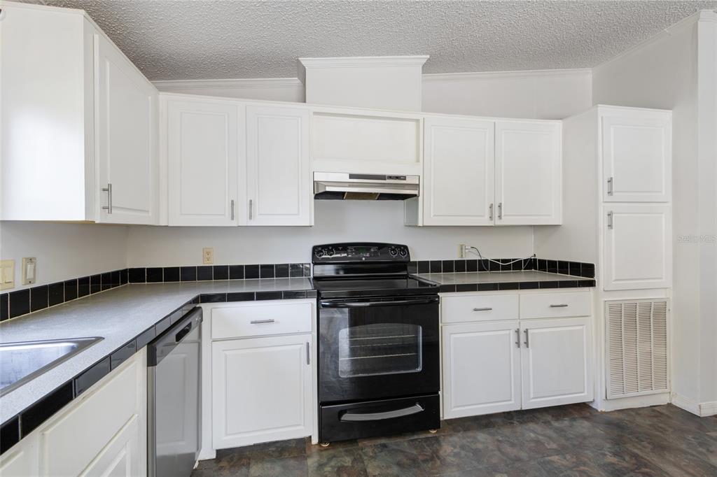 4912 Miley Road Plant City, FL 33565 - Photo 30 of 48 a kitchen with white cabinets and appliances