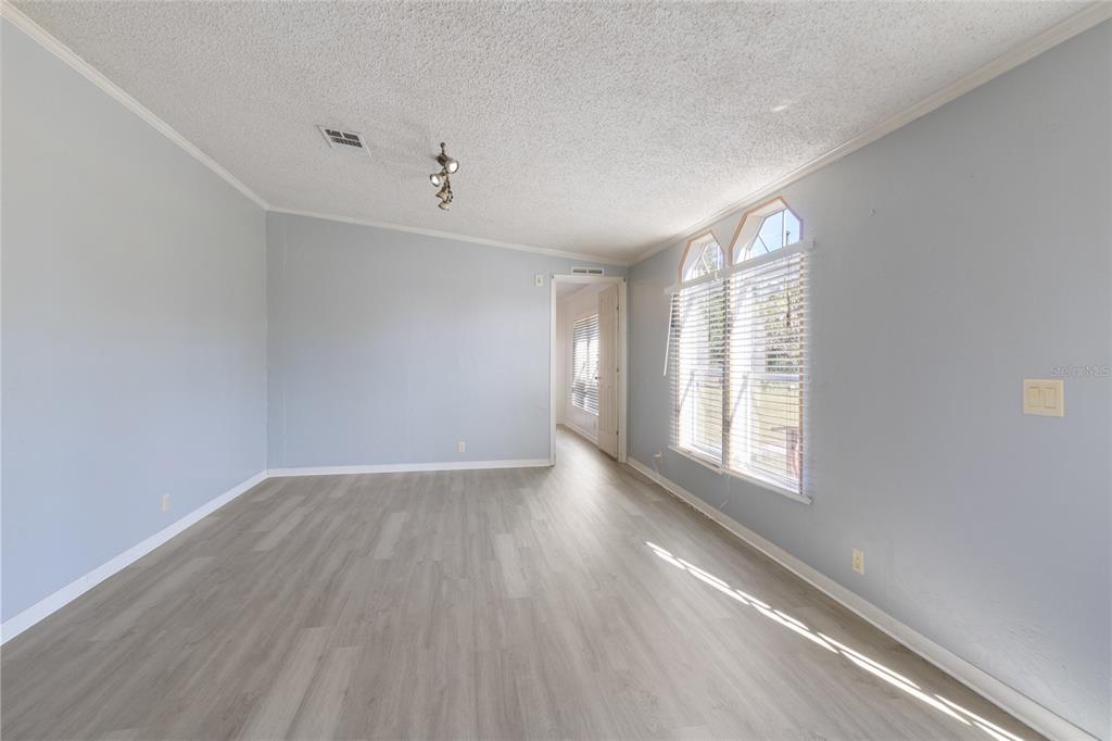 4912 Miley Road Plant City, FL 33565 - Photo 8 of 48 an empty room with wooden floor and windows
