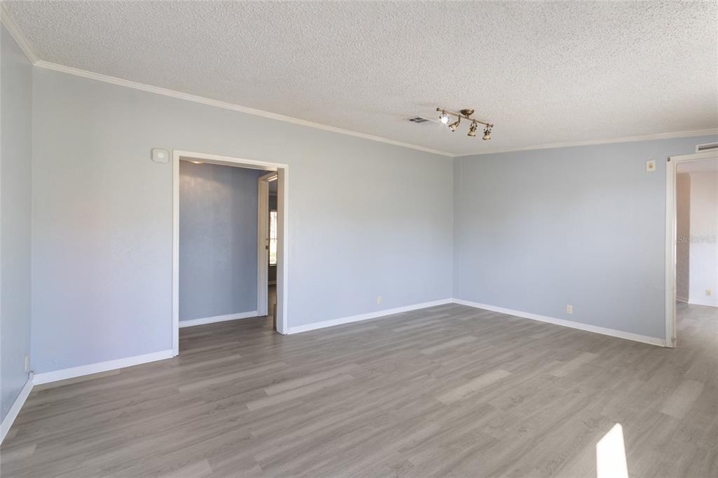 4912 Miley Road Plant City, FL 33565 - Photo 10 of 48 a view of an empty room with wooden floor and a ceiling fan