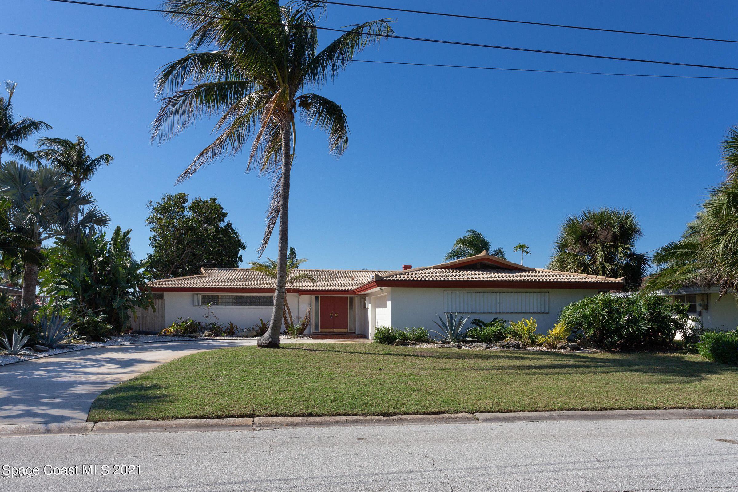 a view of a house with a yard and potted plants