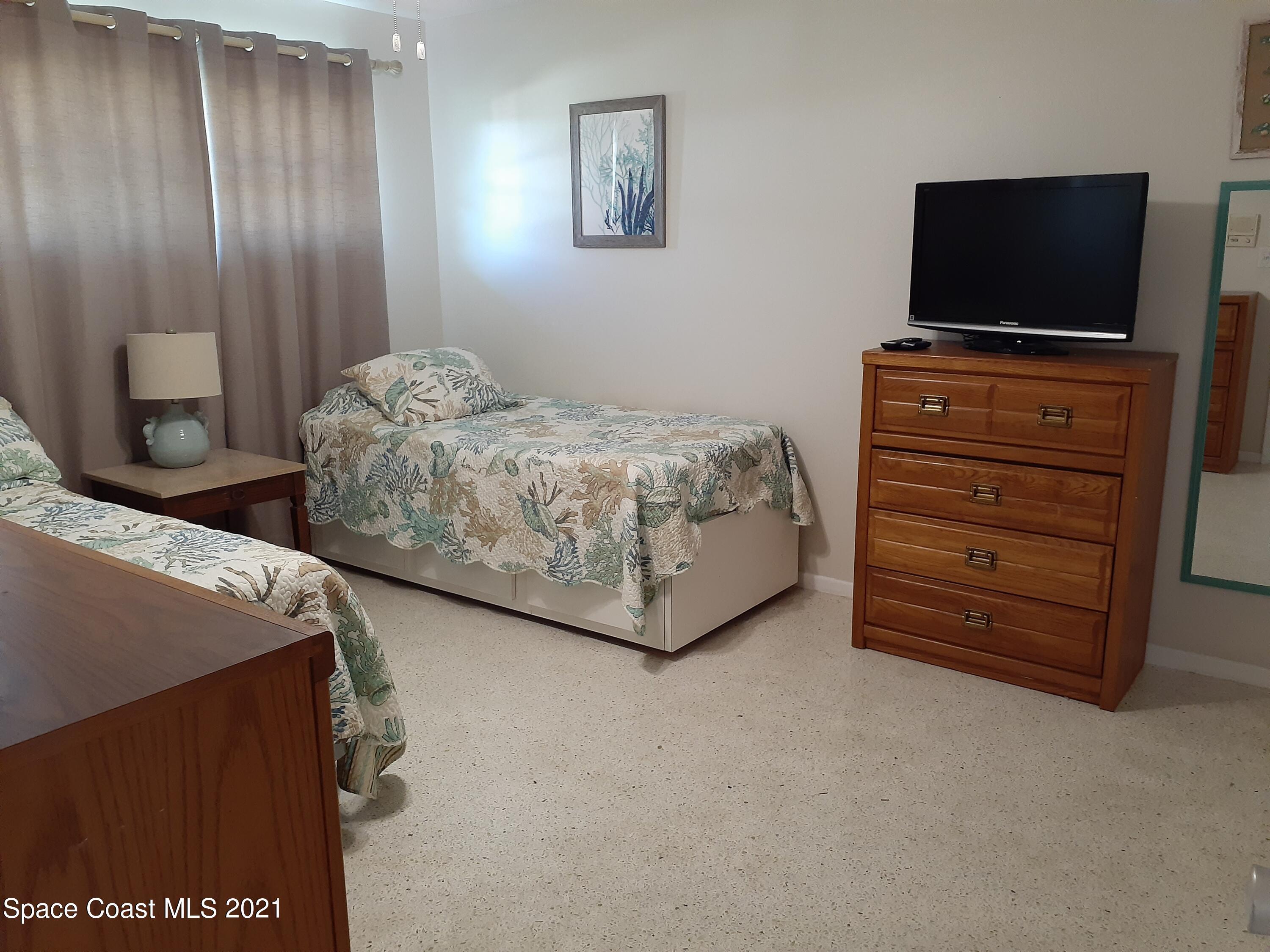 146 Bimini Road Cocoa Beach, FL 32931 - Photo 18 of 37 a bedroom with a bed and a flat screen tv