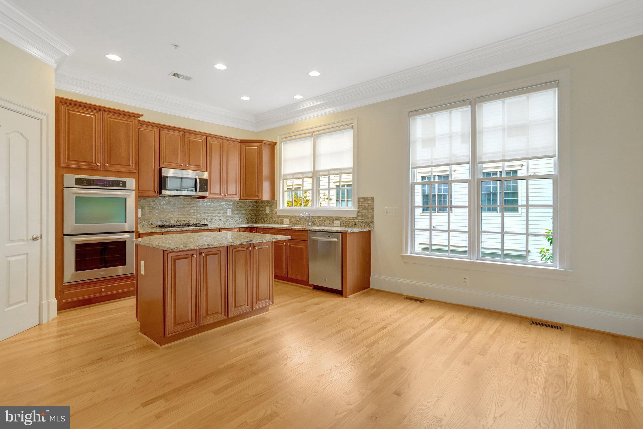 1852 Carpenter Road Alexandria, VA 22314 - Photo 12 of 63 a kitchen with stainless steel appliances granite countertop a stove a sink and a refrigerator with wooden floors