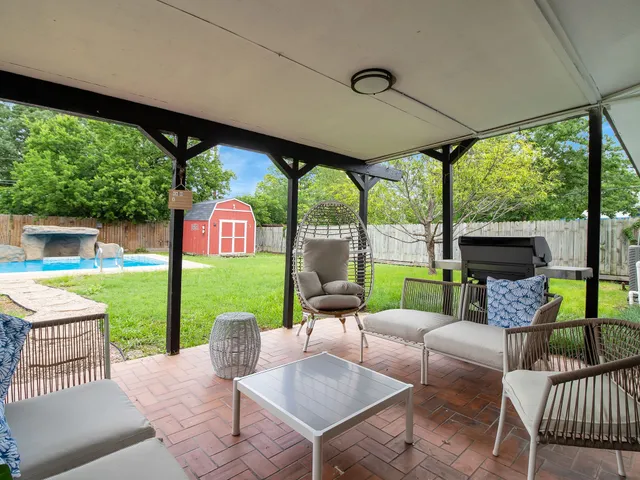 a view of a patio with a table chairs and a backyard
