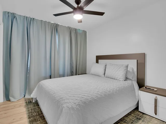 a large bed in a bedroom next to a window