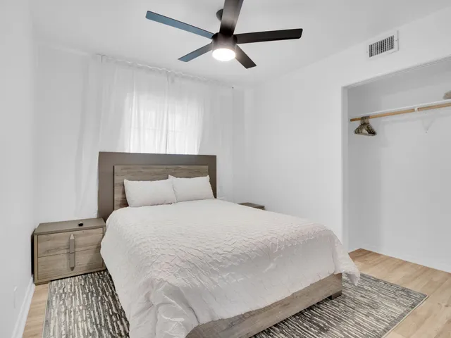a bedroom with a bed and wooden floor