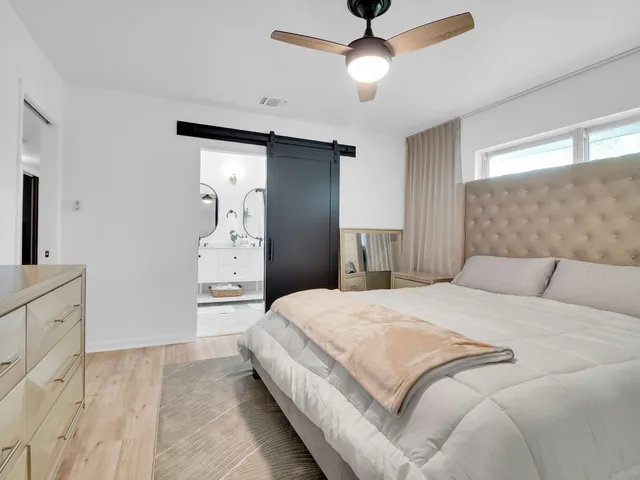 a spacious bedroom with a bed and a chandelier