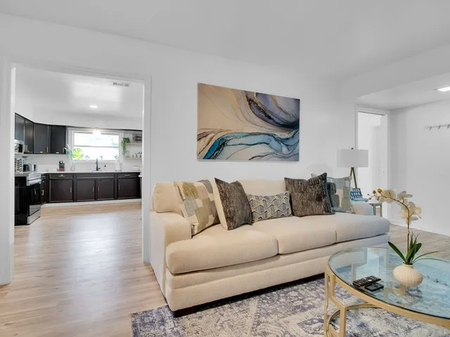 a living room with furniture and a wooden floor