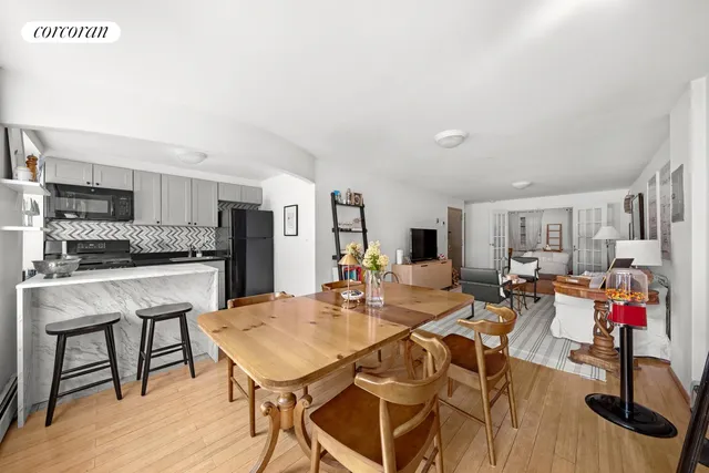 a kitchen with white cabinets and potted plant