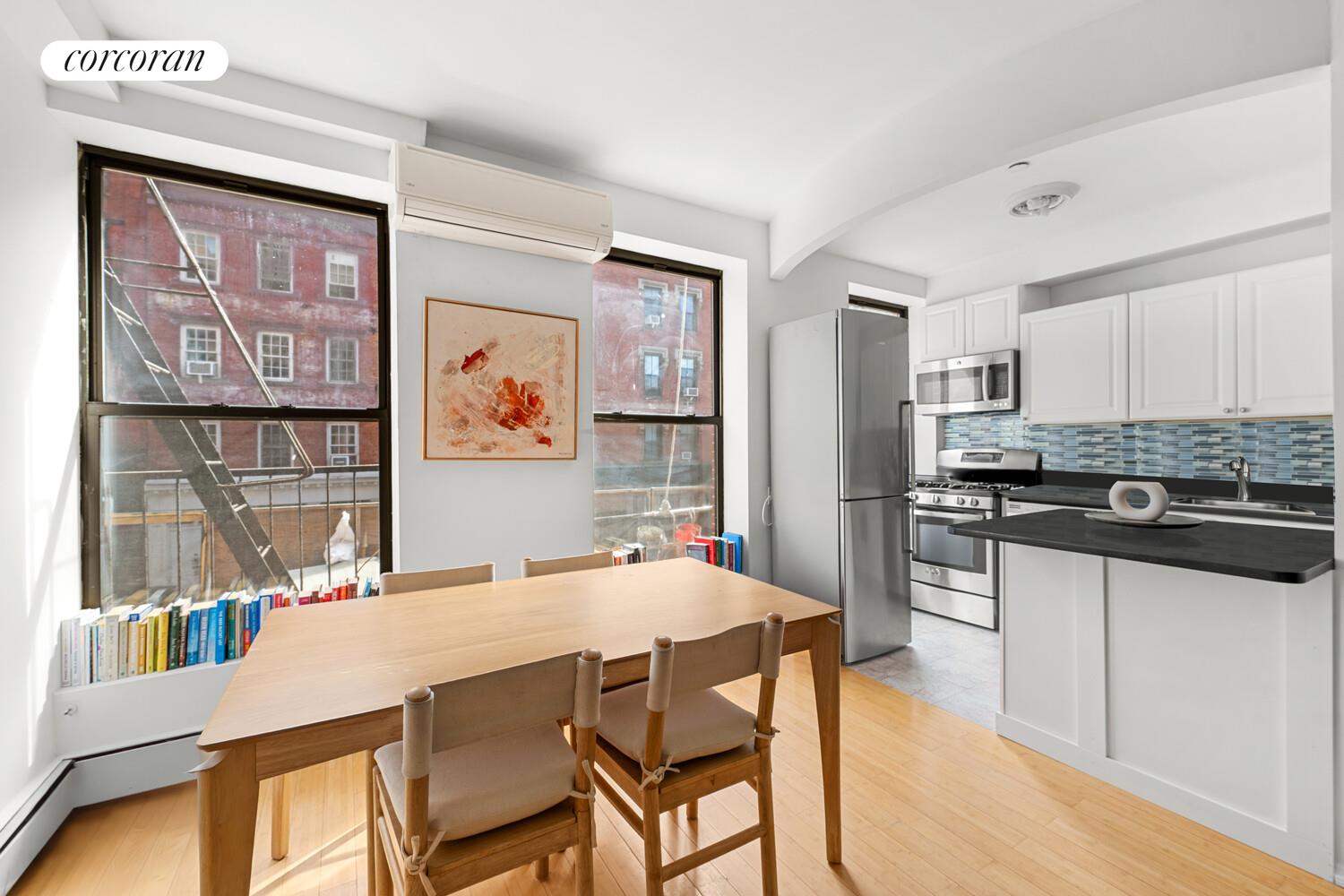 183 Duane Street Manhattan, NY 10013 - Photo 8 of 19 a kitchen with stainless steel appliances kitchen island granite countertop a refrigerator a stove top oven and a dining table with wooden floor