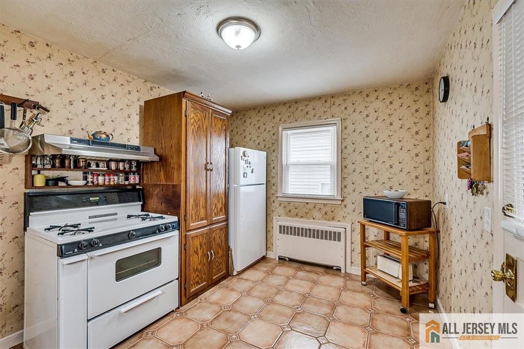 65 Colonial Drive Clark, NJ 07066 - Photo 21 of 44 a kitchen with stainless steel appliances a stove a microwave and a refrigerator