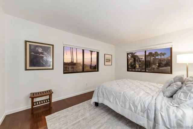 a bedroom with a bed and a wooden floor