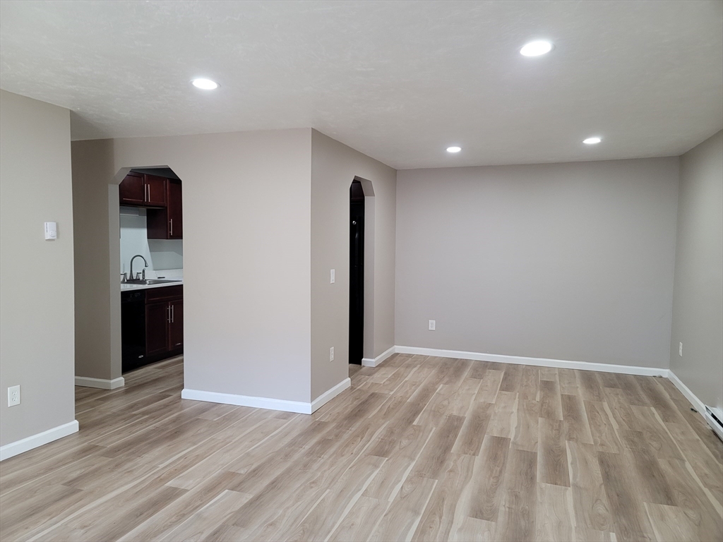 7 Gibbs Street, Unit 7 Worcester, MA 01607 - Photo 6 of 20 an empty room with wooden floor and entrance