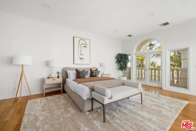 a spacious bedroom with a bed a chandelier and a table