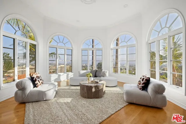 a living room with furniture and floor to ceiling windows