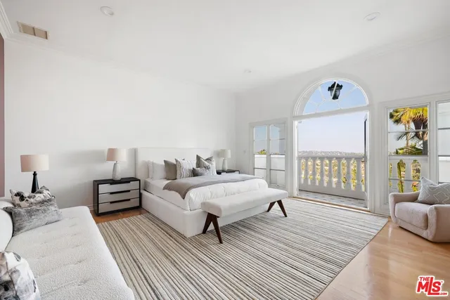 a spacious bedroom with a bed a couch and a window