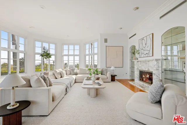 a living room with furniture large window and fireplace