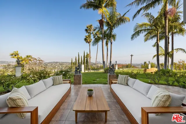 a front view of a house with a garden and trees