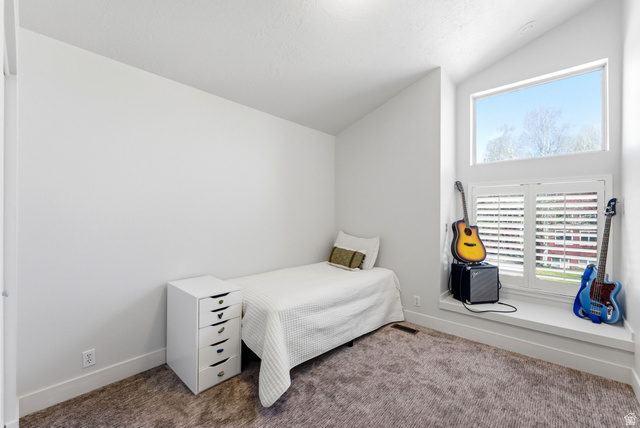 7935 Mustang Loop Road Park City, UT 84098 - Photo 47 of 60 Angled ceiling room featuring a large window with white plantation shutters and a high transom window