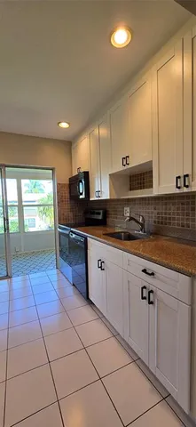 a view of an empty room and a ceiling fan and window
