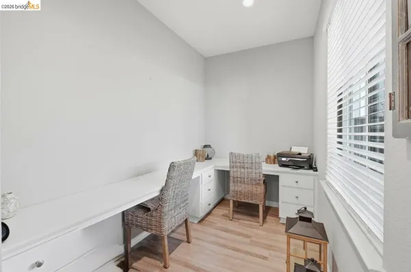 a view of a workspace with furniture and a window