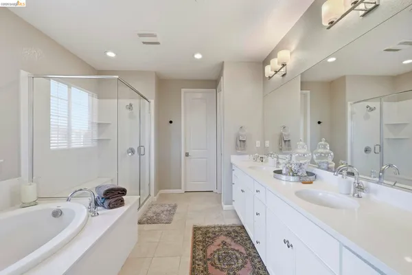 a spacious bathroom with a double vanity sink a mirror and a bathtub