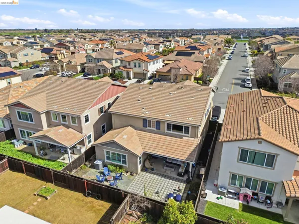 an aerial view of residential houses with yard and mountain view in back