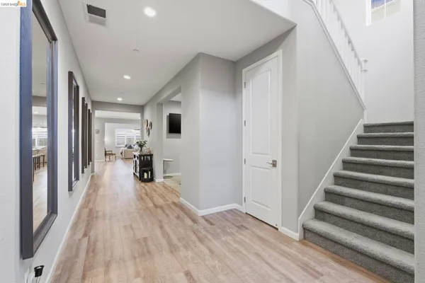 a view of a livingroom with wooden floor and stairs