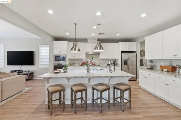 a large kitchen with cabinets table and chairs