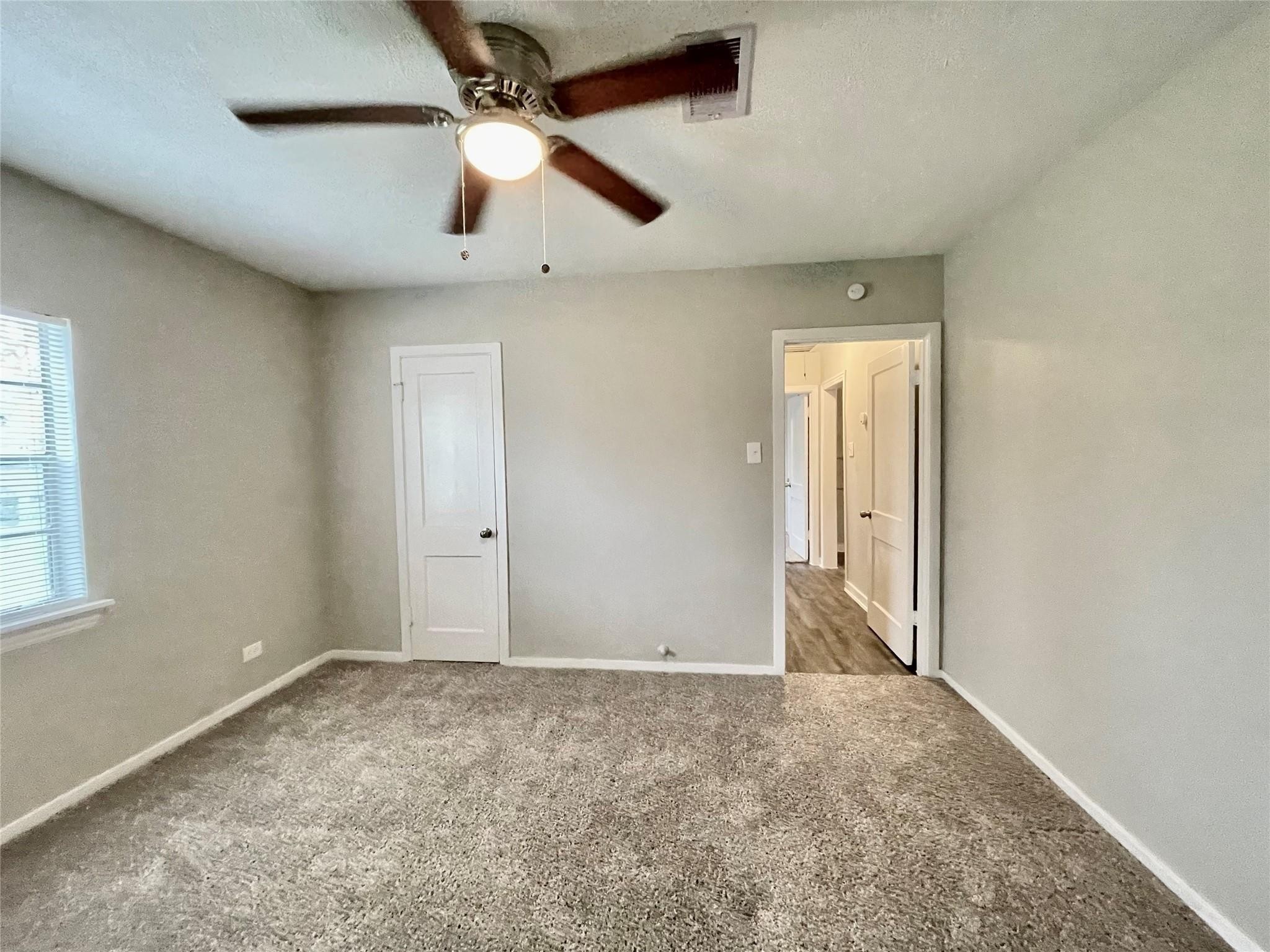 1827 Neuman La Marque, TX 77568 - Photo 13 of 24 en empty room with ceiling fan and window
