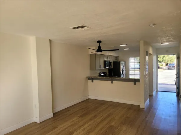 a view of a hallway to room and wooden floor