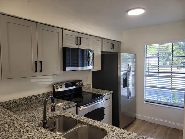 a kitchen with stainless steel appliances granite countertop a stove a microwave and a refrigerator