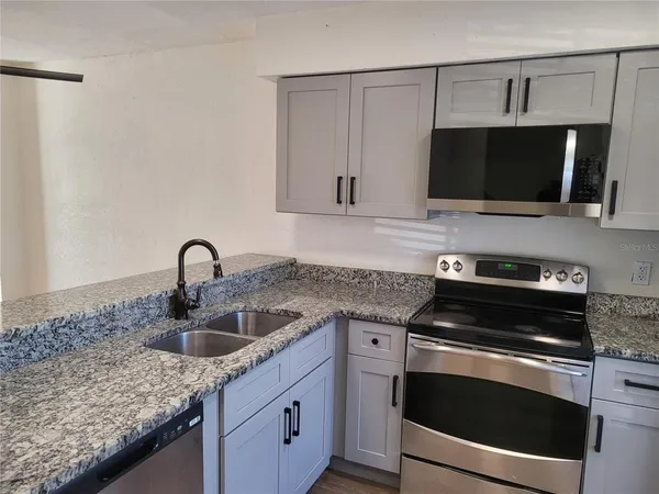 a kitchen with sink microwave and refrigerator
