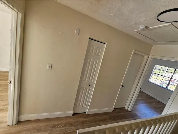 a view of a hallway with wooden floor and a living room