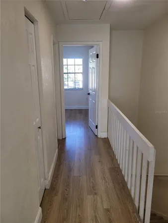 a view of empty room with wooden floor
