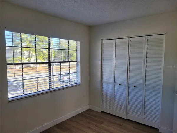 en empty room with wooden floor and windows