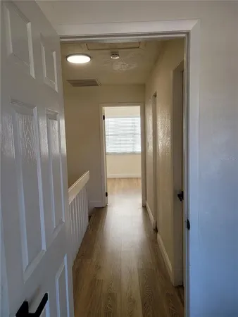 a view of empty room with wooden floor