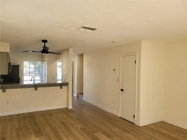 a view of a hallway with wooden floor and a living room