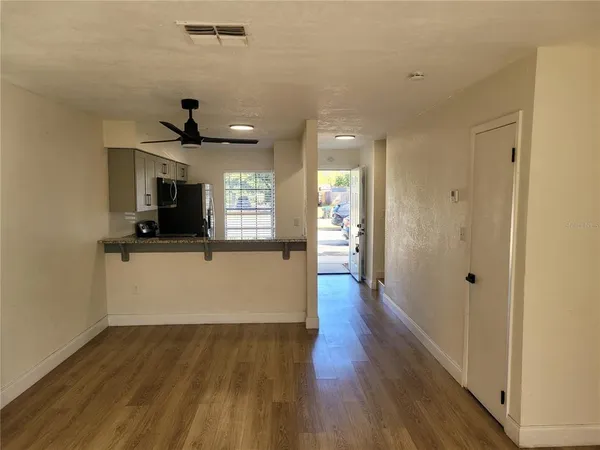 a kitchen with stainless steel appliances granite countertop a sink cabinets and wooden floor