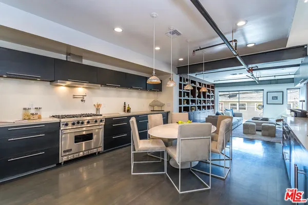 a kitchen with a stove dining table and chairs