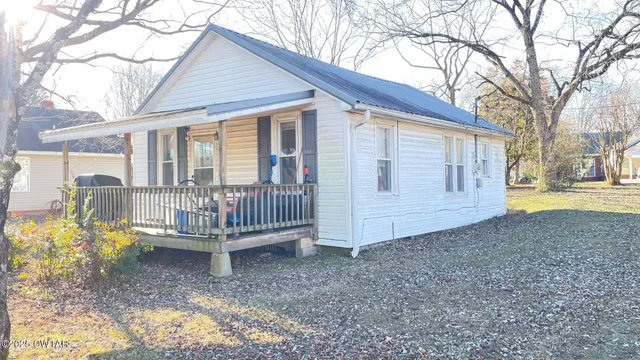 a view of a house with a yard and wooden fence