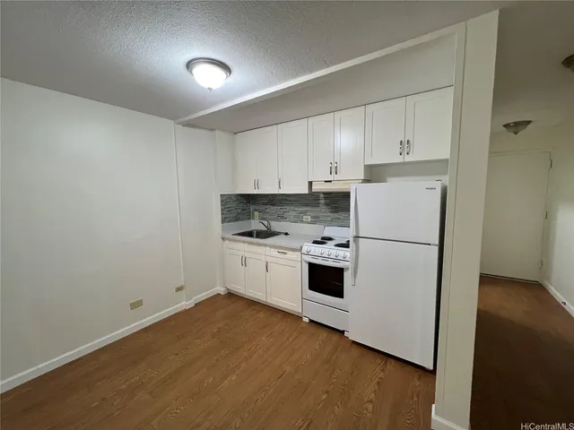 a kitchen with white cabinets and white appliances