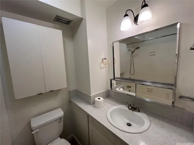 a bathroom with a sink a toilet and mirror