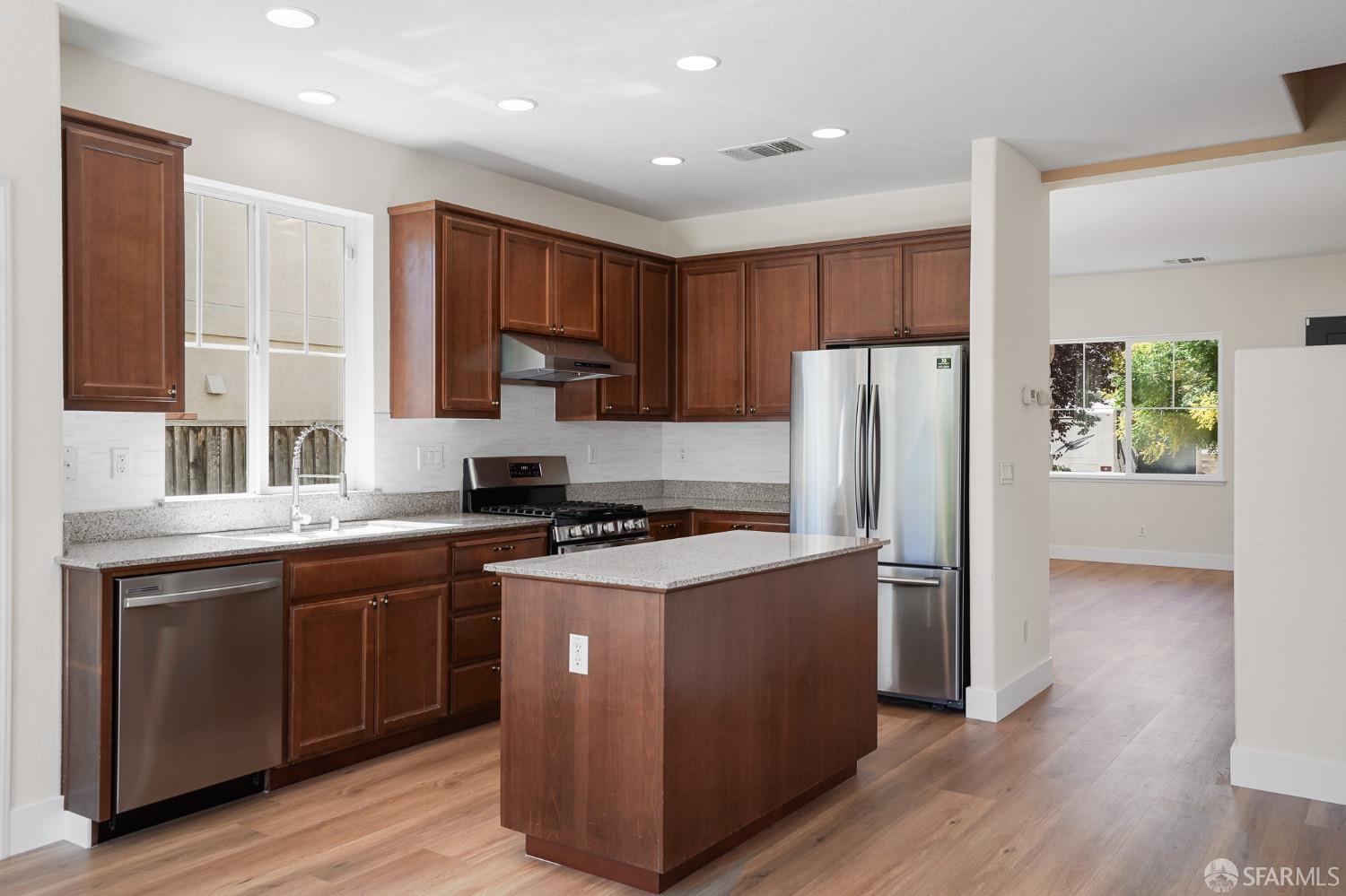 5290 Sungrove Way Antioch, CA 94531 - Photo 13 of 47 a kitchen with stainless steel appliances granite countertop a stove a refrigerator a sink and dishwasher with wooden floor