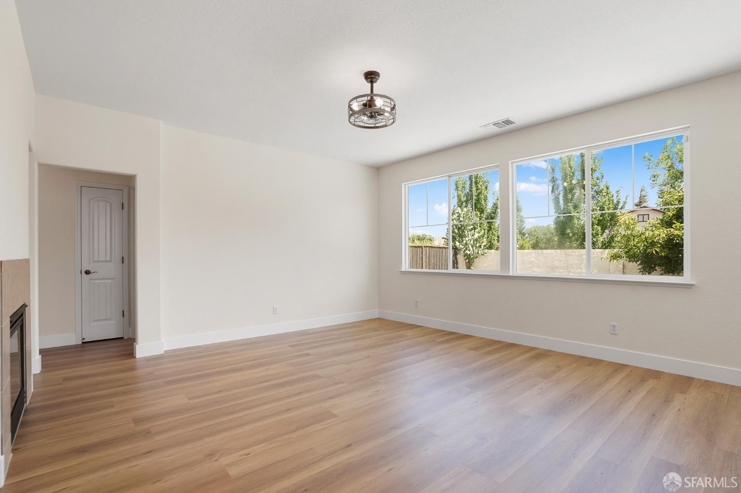 5290 Sungrove Way Antioch, CA 94531 - Photo 15 of 47 a view of an empty room with wooden floor and a window