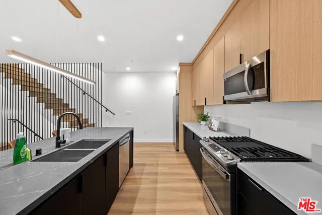 a kitchen with granite countertop stainless steel appliances and sink