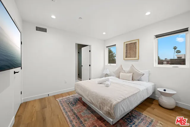 a bedroom with a bed and painting on the wall