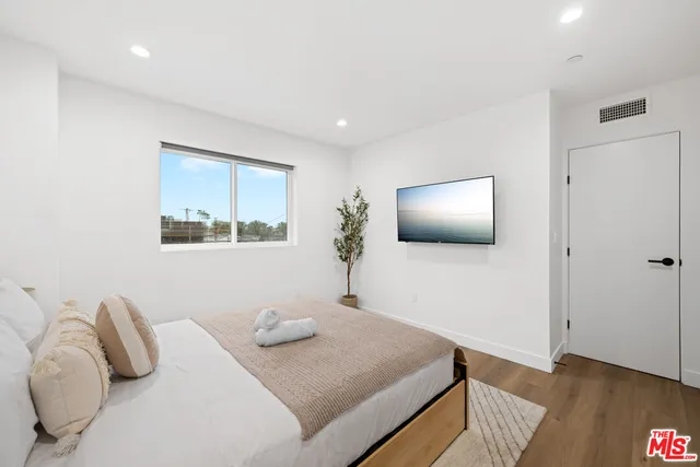 a bedroom with a bed and a flat screen tv